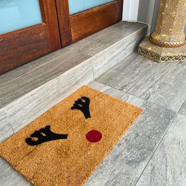 Doormat with reindeer antlers and a red nose