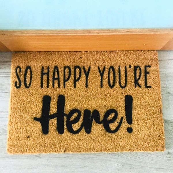 Doormat that says 'So happy you're here!'