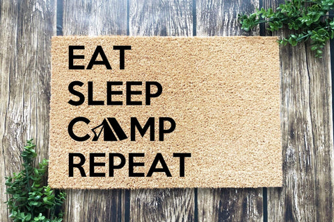 Doormat that says 'Eat Sleep Camp Repeat'. The A in Camp is a tent.