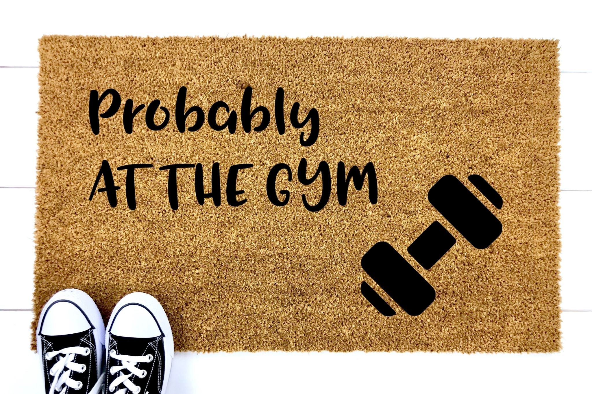Doormat that says Probably At The Gym with a picture of a dumbbell
