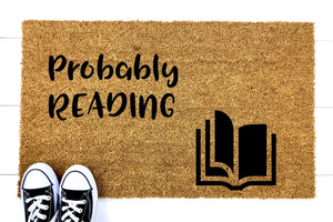 Doormat that says 'Probably Reading' with a picture of a book