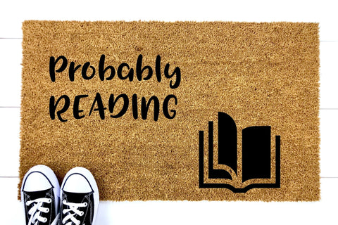 Doormat that says 'Probably Reading' with a picture of a book